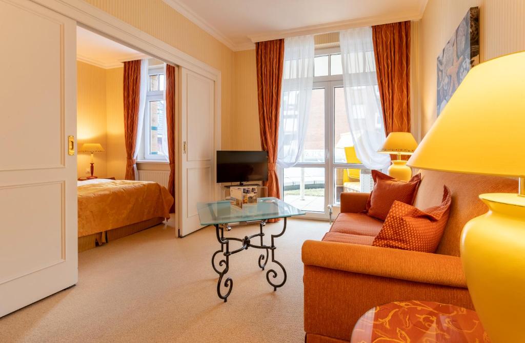 a hotel room with a bed and a couch and a table at Strandhotel Sylt Westerland in Westerland