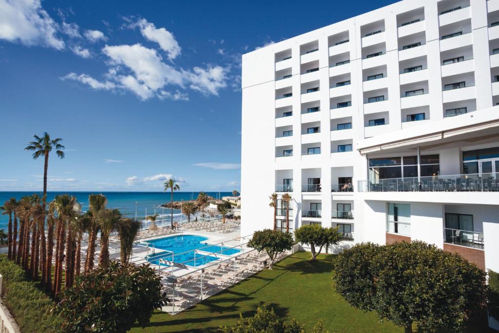 an exterior view of a hotel with a view of the ocean at Hotel Riu Monica - Adults Only in Nerja