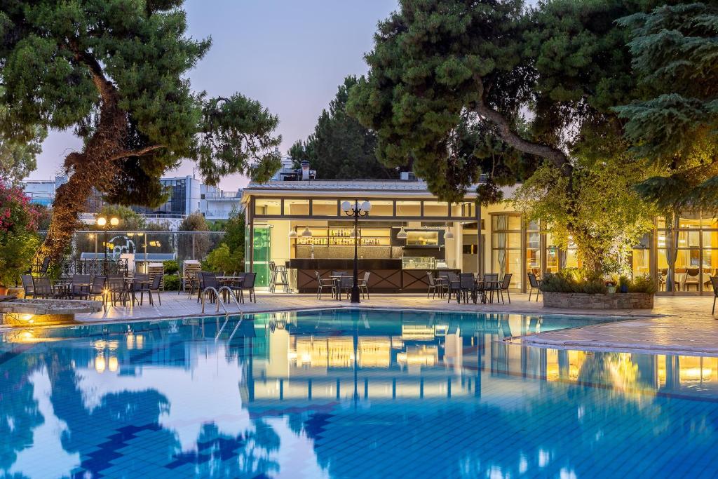 una piscina con un edificio sullo sfondo di Oasis Hotel Apartments ad Atene