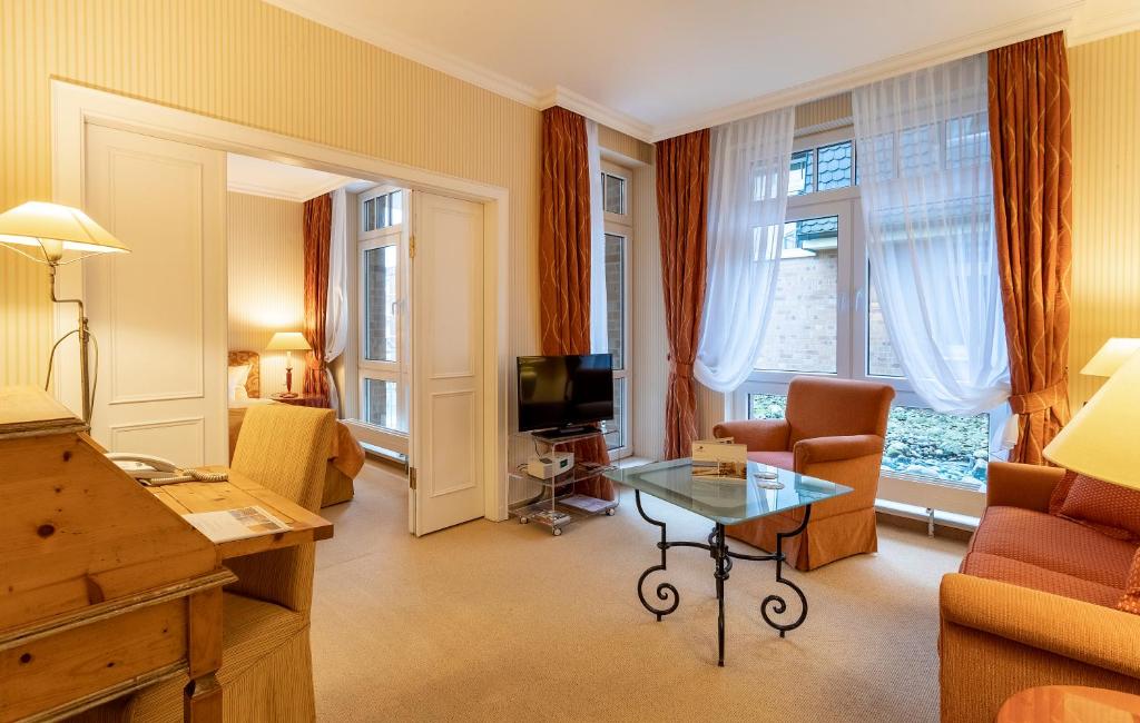 a living room with a couch and a table at Strandhotel Sylt Westerland in Westerland