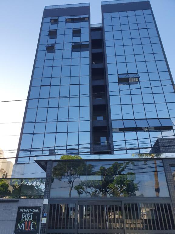 un edificio de cristal alto con un cartel delante en Residencial Portville Pajuçara, n 1495, en Maceió