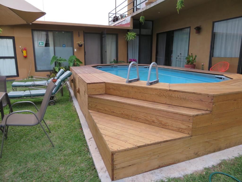 una piscina con terrazza in legno accanto a una casa di Posada Casa Topiltzin a Tepoztlán
