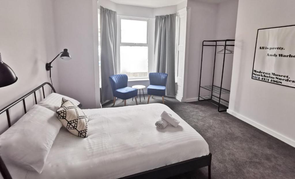 een slaapkamer met een bed, een stoel en een raam bij Richmond Apartments by Switchback Stays in Cardiff