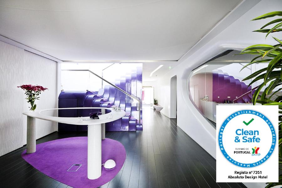 ヴィアナ・ド・カステロにあるAbsoluto Design Hotelのテーブルと紫の敷物が備わる部屋