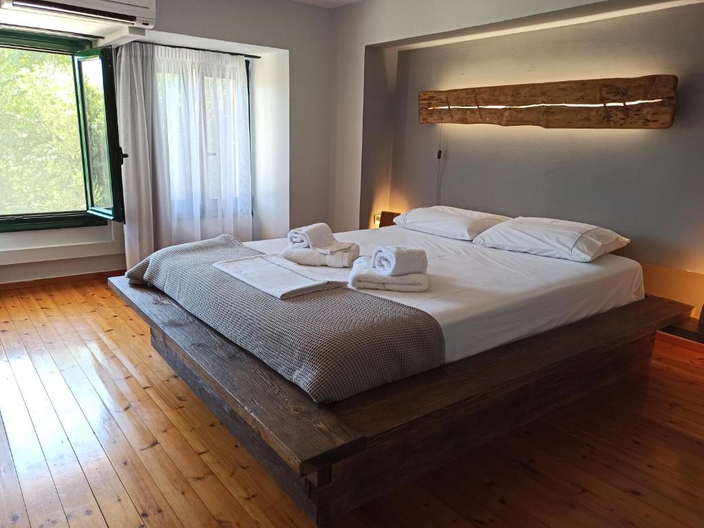 a bedroom with a large bed with towels on it at Cozy Residences in the center of Volissos Village - Lydia Lithos- in Volissos
