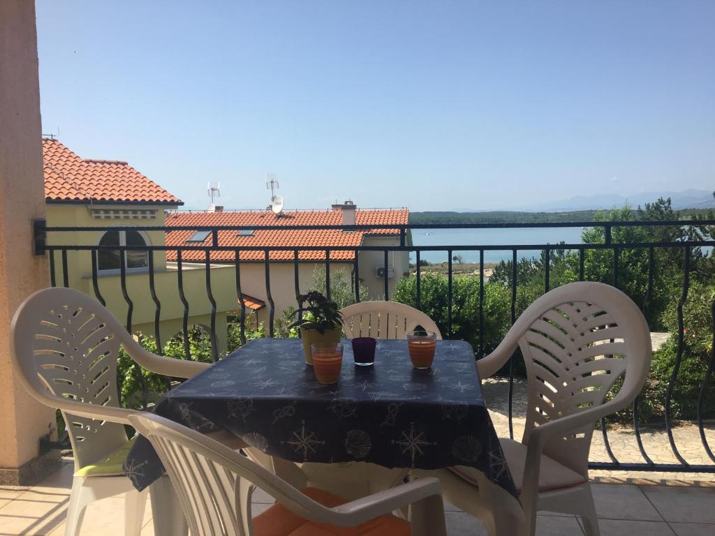 a table and chairs on a balcony with a view of the water at Apartment Mario 2 in Klimno