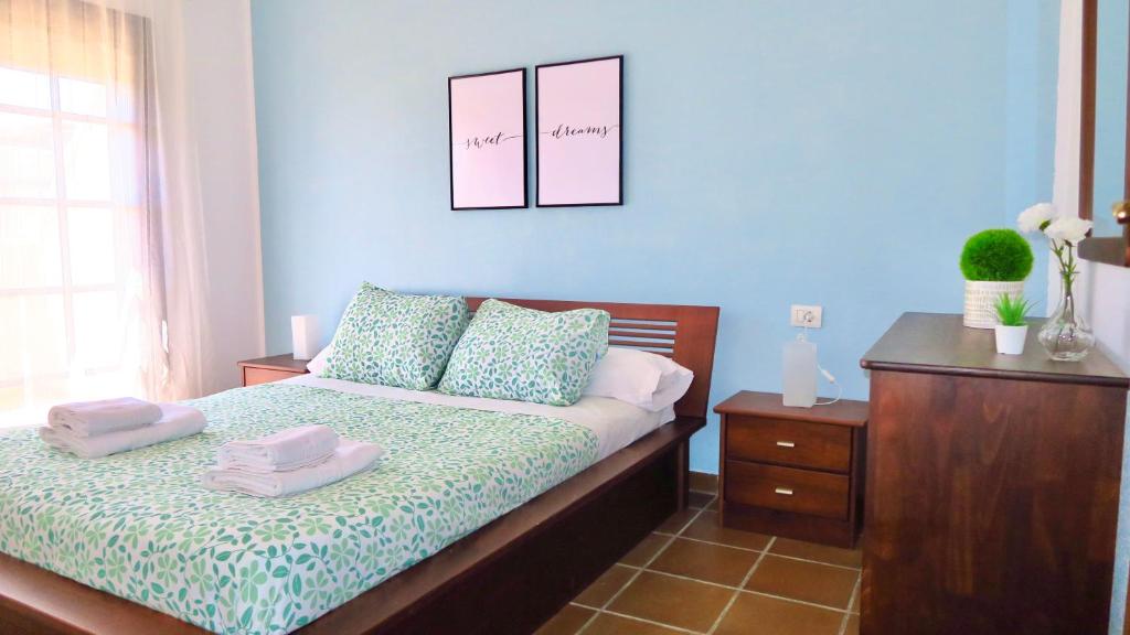a bedroom with a bed with two towels on it at Ohana Adosado El Médano in El Médano