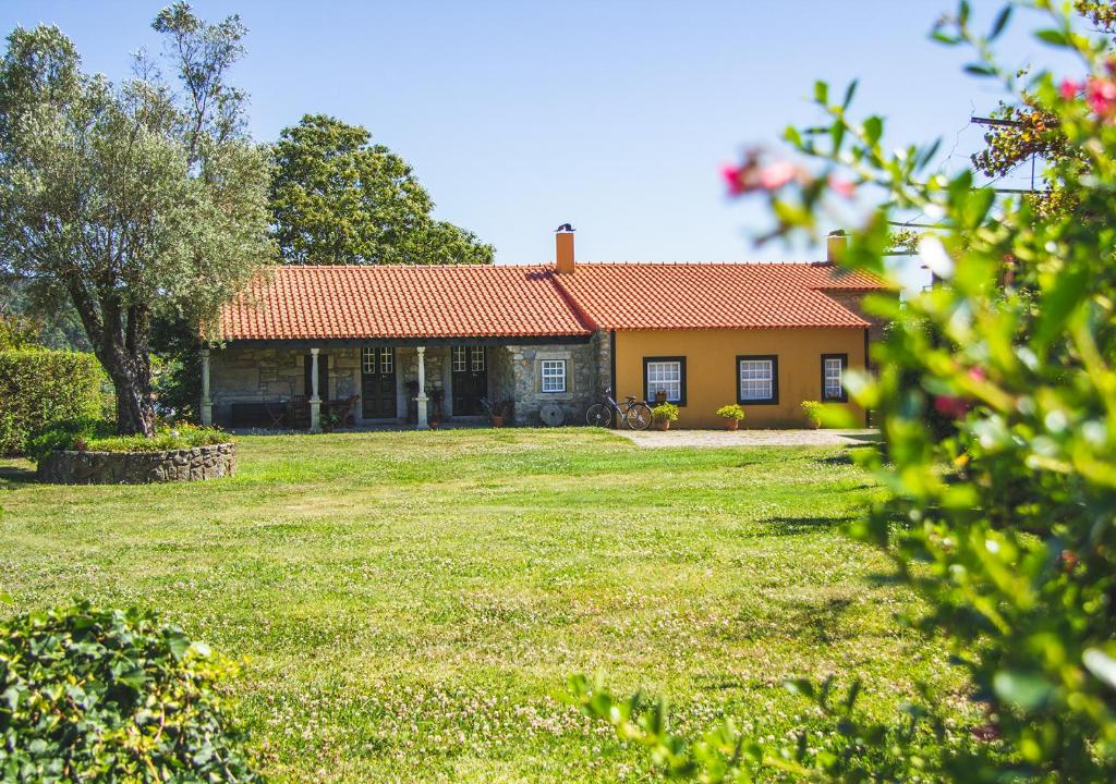 a house with an orange roof and a yard at Casa da Quinta do Outeiro in Viana do Castelo
