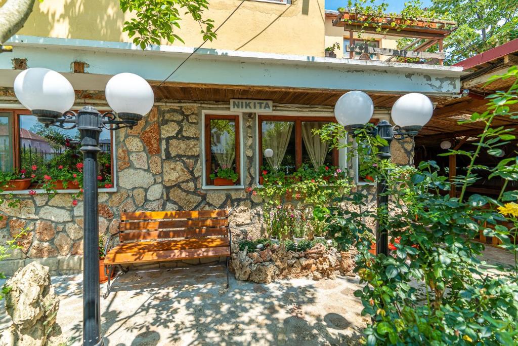 a bench in front of a building with a stone wall at Casa Nikita in Vama Veche