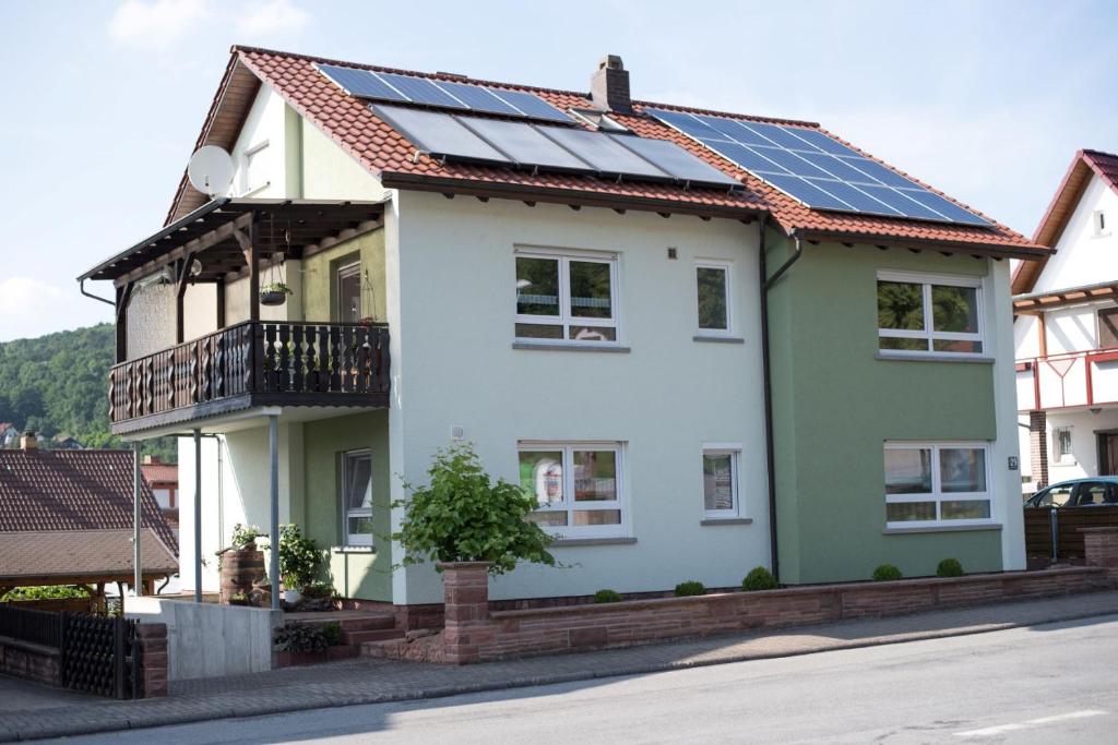uma casa com painéis solares no telhado em Ferienwohnung Münch mit Balkon em Großheubach