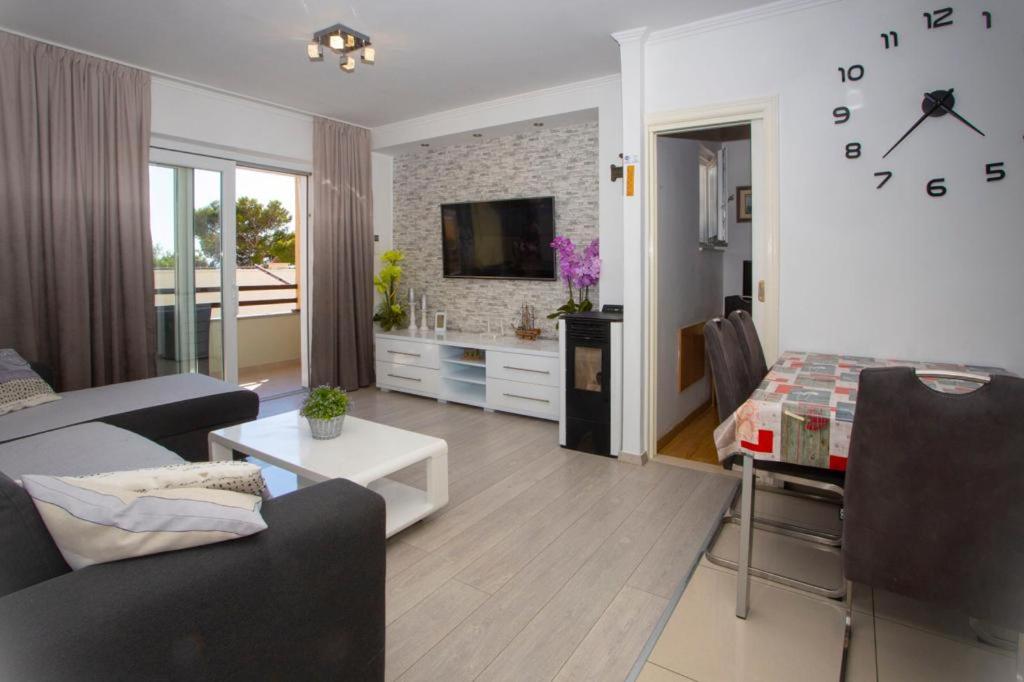 een woonkamer met een bank, een tafel en een klok bij Apartment San Marino in Makarska