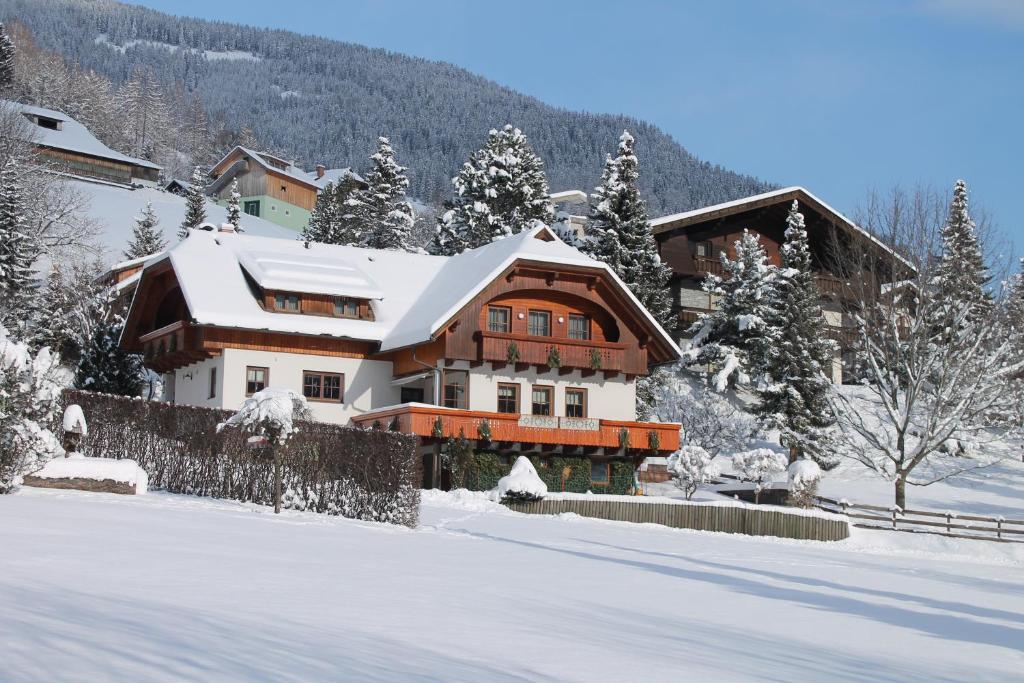 ein Haus im Schnee mit schneebedeckten Bäumen in der Unterkunft Haralds Ferienwohnungen in Bad Kleinkirchheim