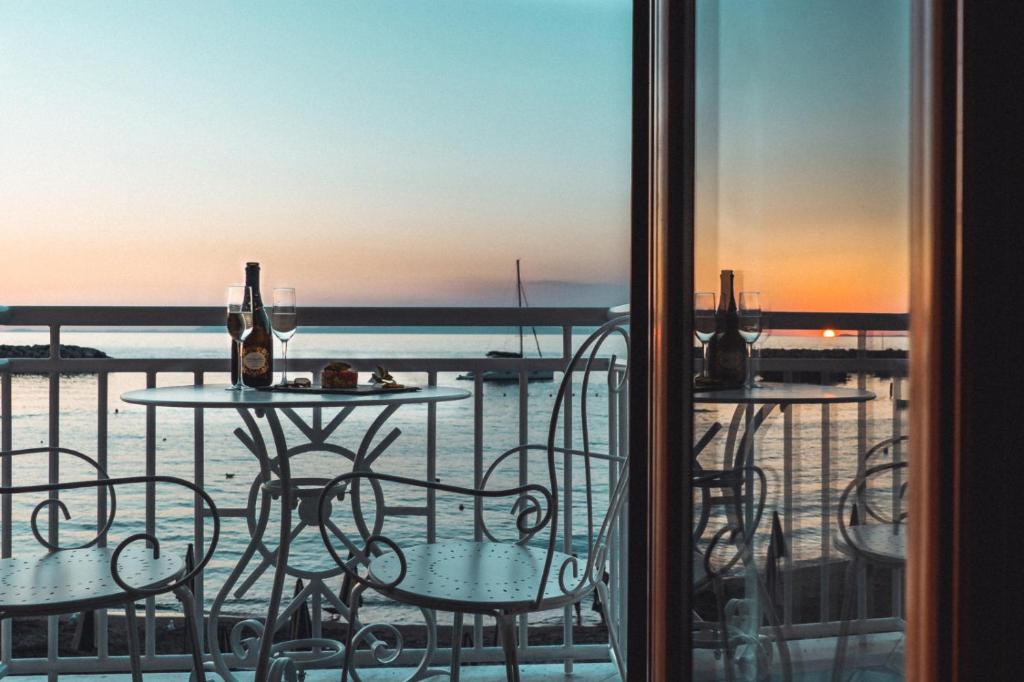 un tavolo e sedie su un balcone con vista sull'oceano di Sapphire Rooms a Massa Lubrense