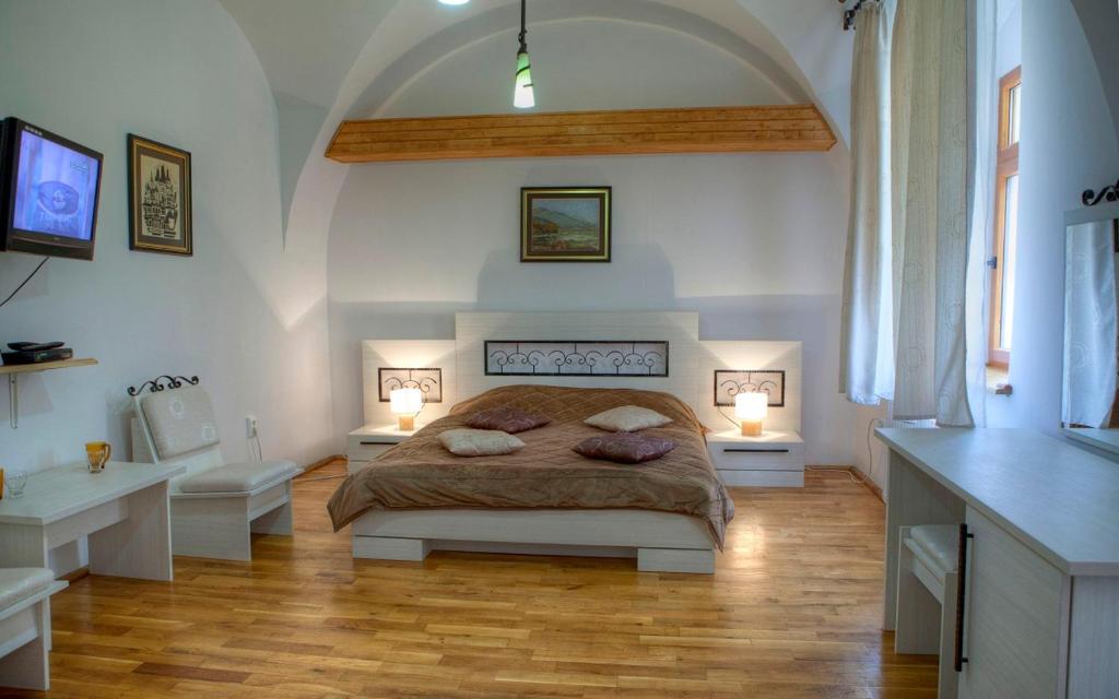 a bedroom with a large bed and two lamps at Piata Sfatului Central Confort in Braşov