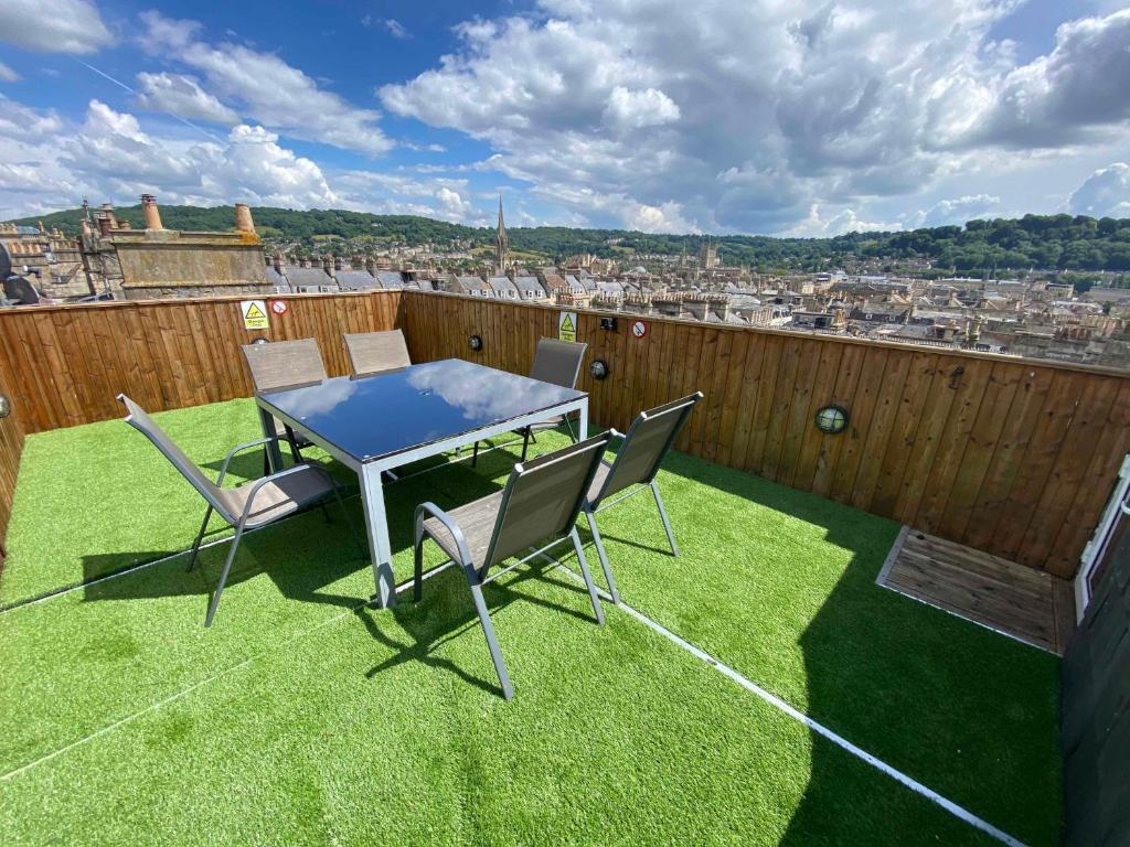 un patio con mesa y sillas en el césped en Bath Roof Terrace Apartment, City Centre, Sleeps up to 8, en Bath