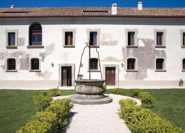 duży biały budynek z fontanną na dziedzińcu w obiekcie Relais Villa Giusso w mieście Vico Equense