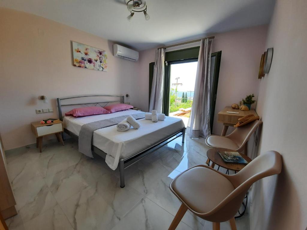 1 dormitorio con 1 cama, 2 sillas y ventana en Freesia Grand Sea View Residence, en Sarláta