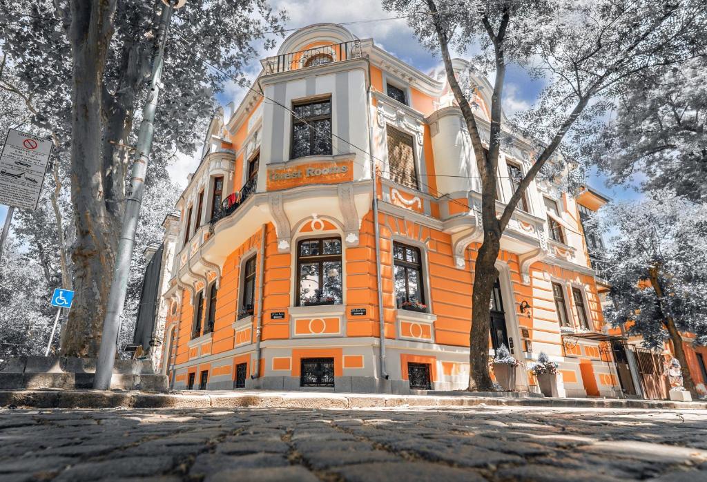 an orange and white building with trees in front of it at My Guest Rooms in Plovdiv