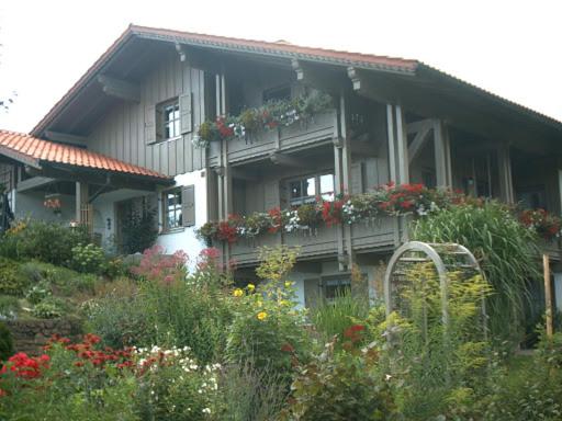 uma casa com flores ao lado dela em Ferienwohnung Peschl Langdorf Bayerischer Wald em Langdorf