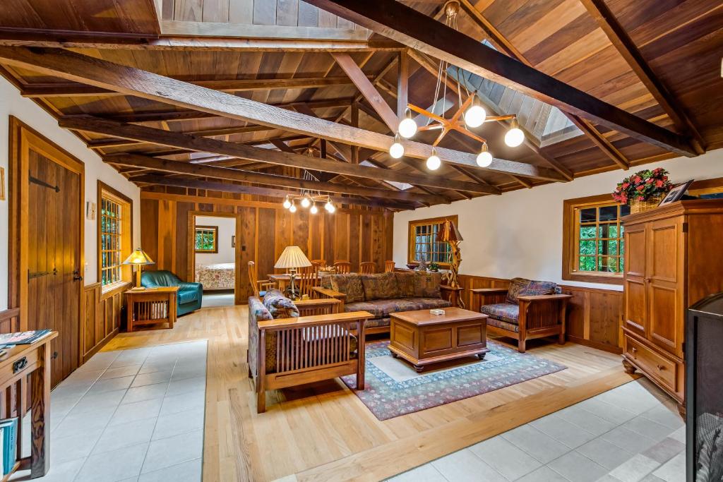 a living room with wooden walls and a ceiling with beams at Little River Redwoods in Little River