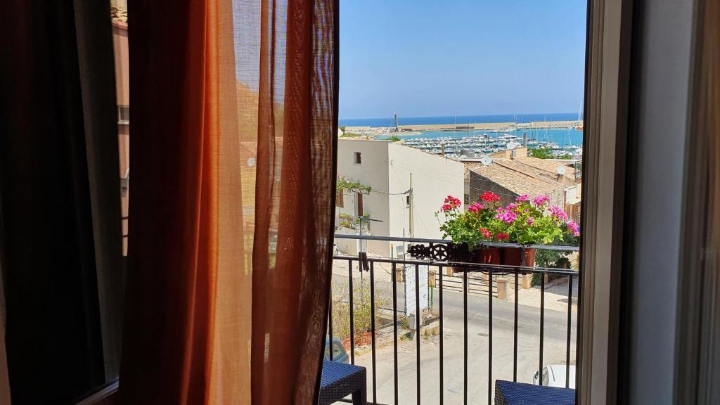 a room with a balcony with a view of a city at Cerri Hotel in Castellammare del Golfo