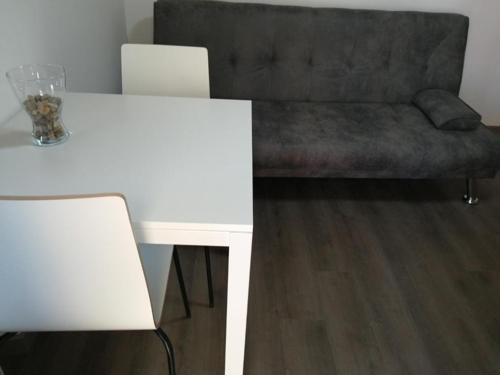 a white table and a couch in a room at Apartamento A Fabrica in Santiago de Compostela