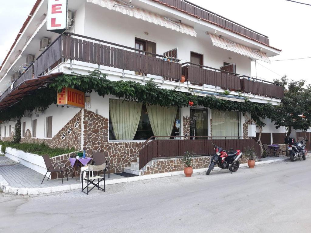 a building with a motorcycle parked in front of it at Hotel Paralia in Nea Karvali