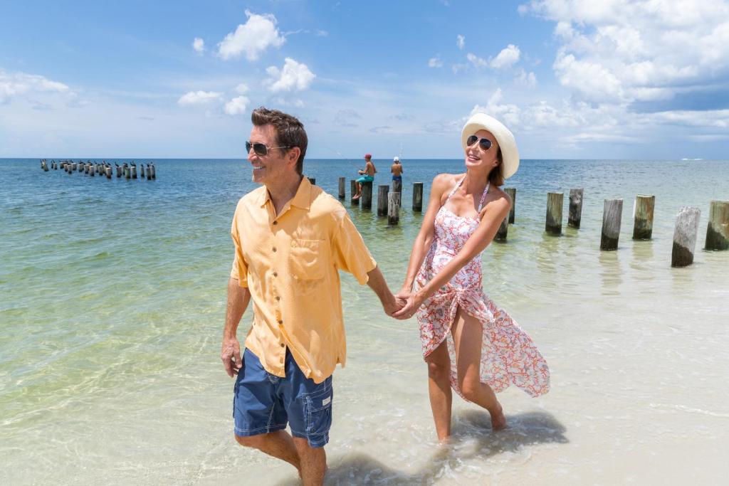 a man and a woman walking on the beach at Inn On Fifth in Naples