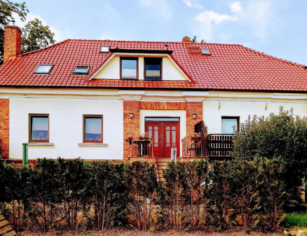 ein weißes Haus mit rotem Dach in der Unterkunft Rügenurlaub 2 in Garftitz