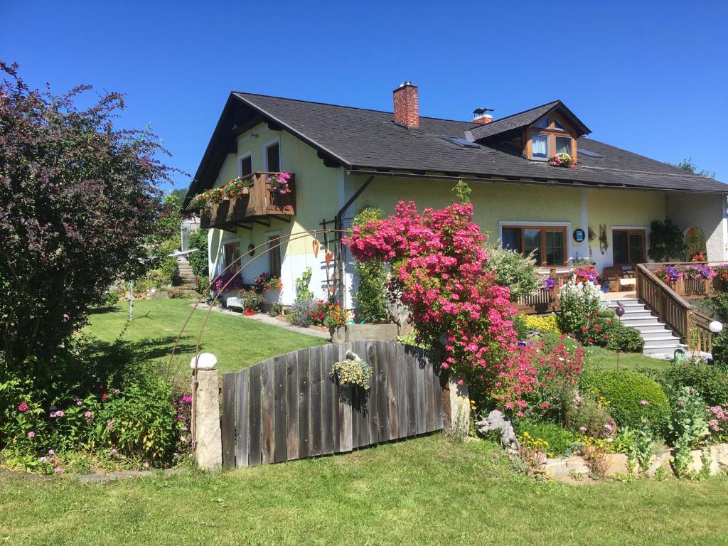 Arbesbach的住宿－Gästehaus Huber，院子中带围栏和鲜花的房子