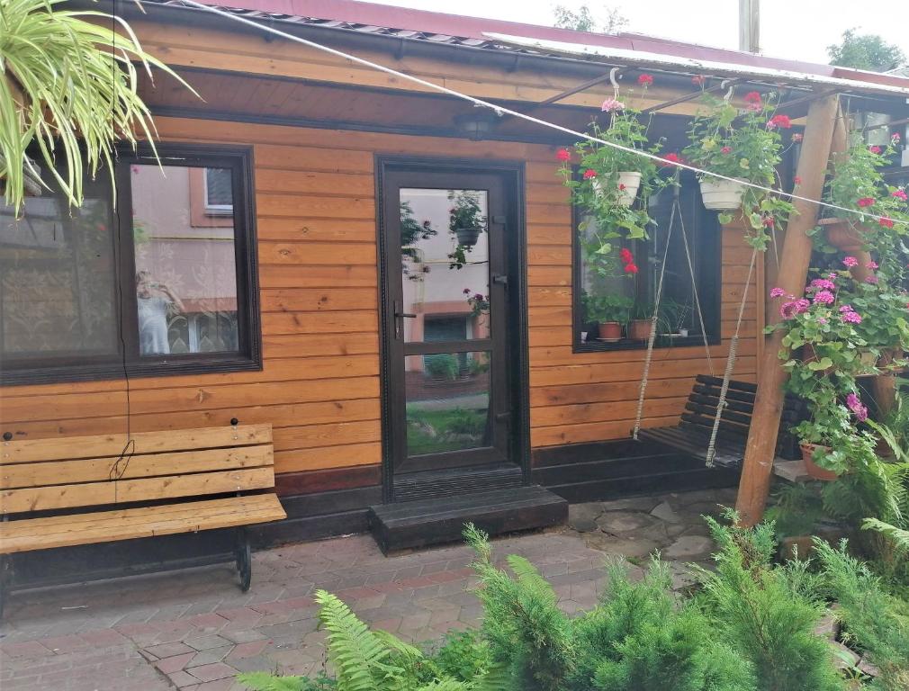 eine Holzhütte mit einer Bank im Garten in der Unterkunft Деревянный 2-х комнатный домик in Kiew