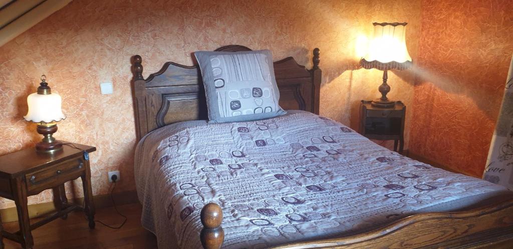 a bedroom with a large bed with two lamps at La mouche,chambres avec terrasse vue sur la rivière in Humes