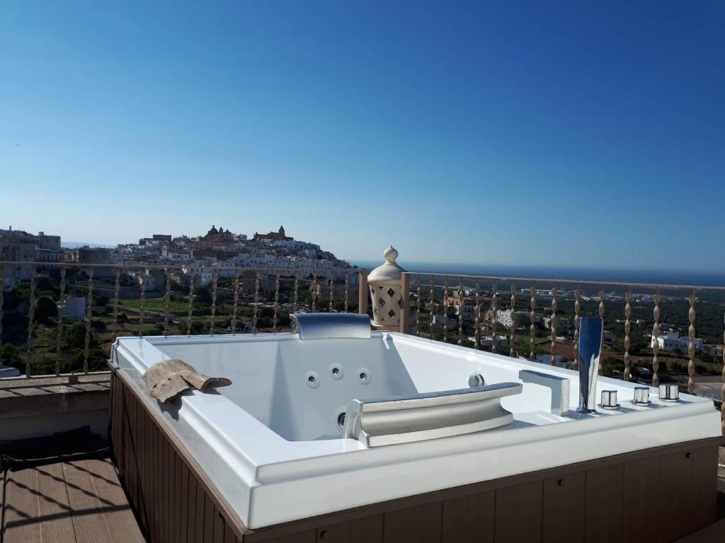 a bath tub on top of a balcony with the ocean at Biancadamare in Ostuni