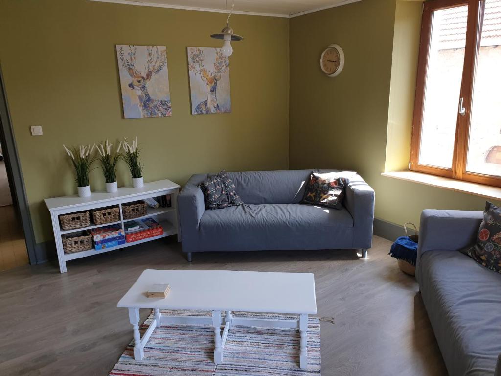 a living room with a couch and a coffee table at Au Pied du Gazon in Saint-Maurice-sur-Moselle