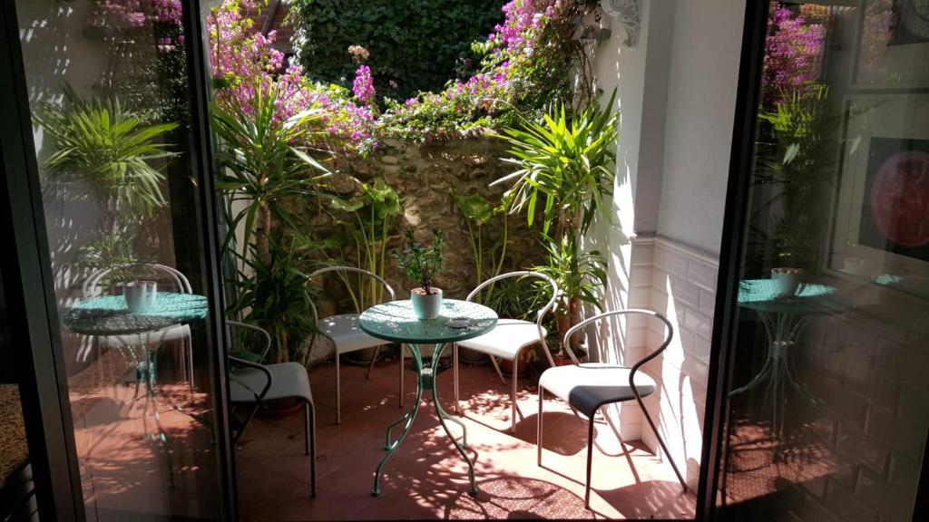 La Casa Del Nueve في خيرتي: فناء به طاولتين وكراسي وورود