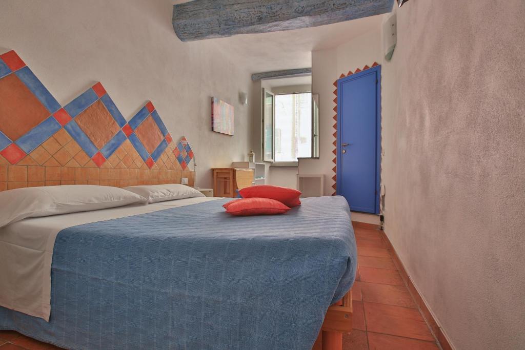 Un dormitorio con una cama con almohadas rojas. en CATEO, en Riomaggiore