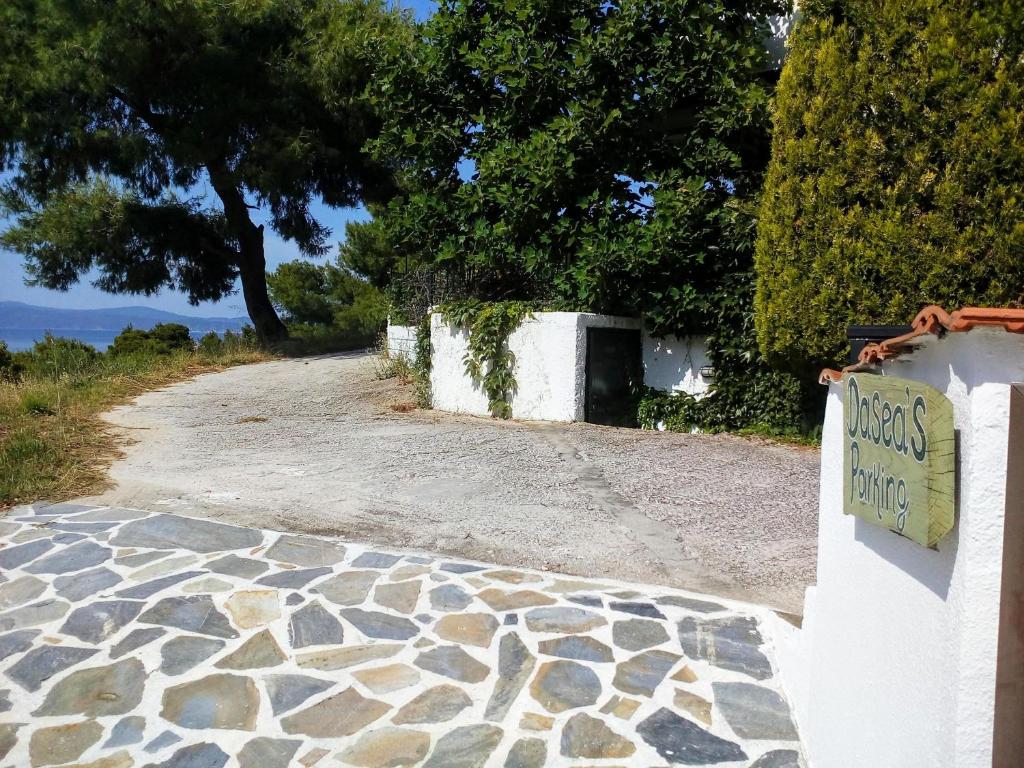 a sign on a wall next to a dirt road at Dasea Houses in Ormos Panagias
