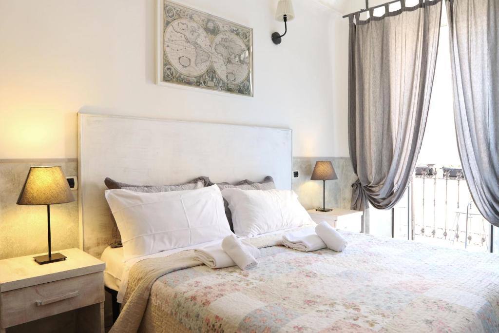 una camera da letto con un letto con due lampade e una finestra di Guest House Relais Indipendenza a Roma