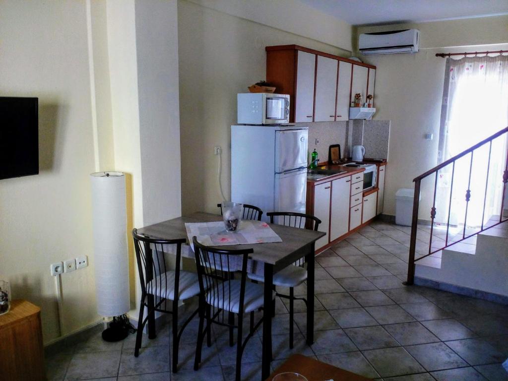 a kitchen with a table and chairs and a refrigerator at Dasea Houses in Ormos Panagias