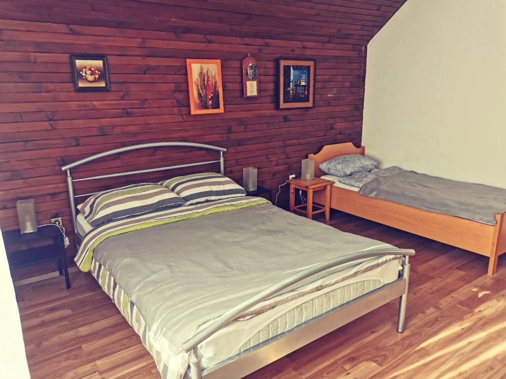 um quarto com 2 camas e paredes de madeira em Apartma Rekar - a house, where you can relax in the embrace of nature em Jesenice