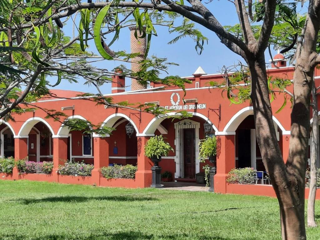 een oranje gebouw met een boom ervoor bij Hacienda Santa Clara, Morelos, Tenango, Jantetelco in Jantetelco