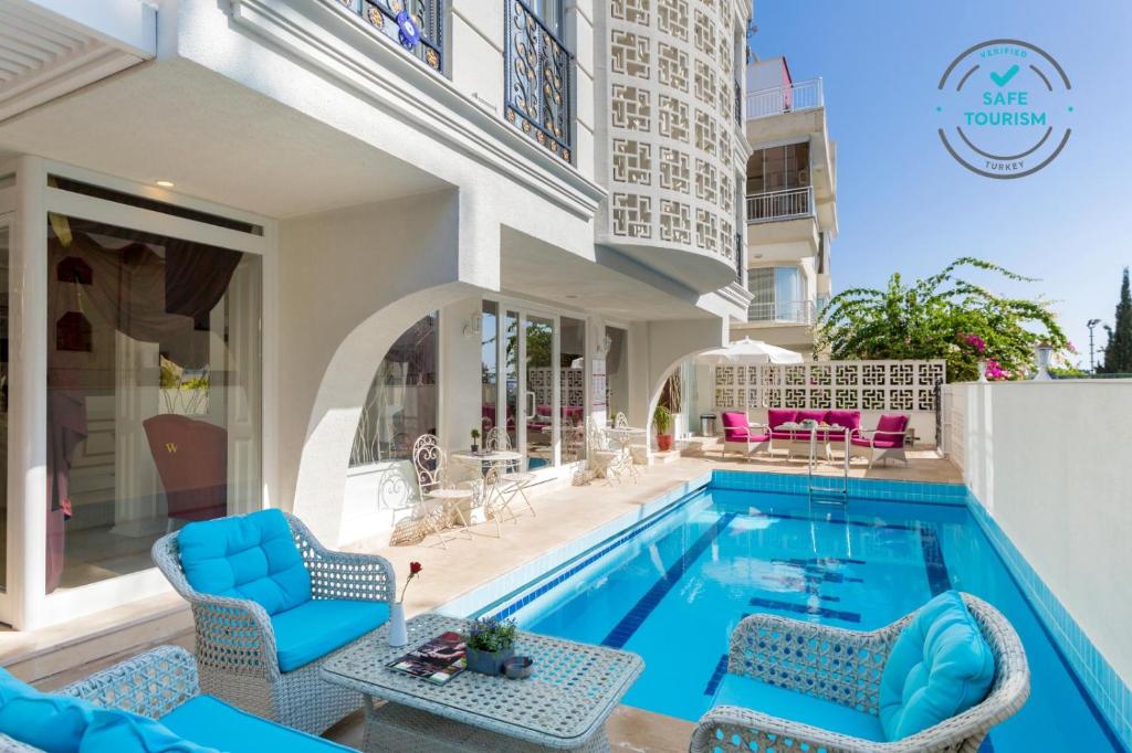 a villa with a swimming pool and chairs at Wise Hotel & Spa - Adults Only in Antalya