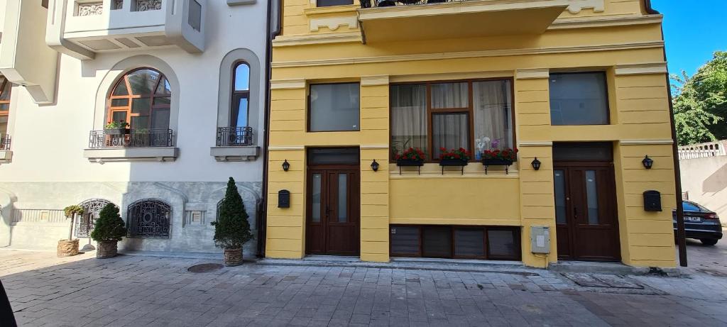 een geel gebouw met twee deuren en bloemen erop bij Cazino4Love in Constanţa