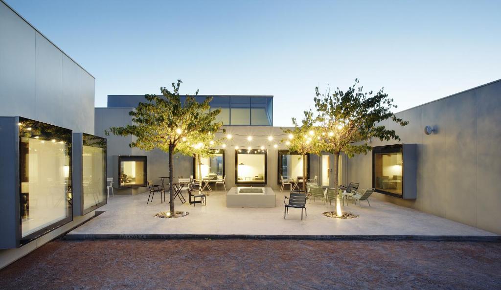 un patio con sillas y mesas frente a un edificio en Hotel Aire de Bardenas, en Tudela