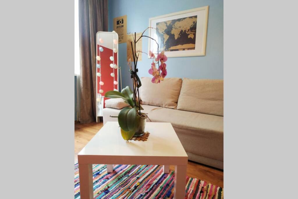 ヴィリニュスにあるSlucko Central Studio Apartment near Riverのリビングルーム(植物のあるテーブル付)