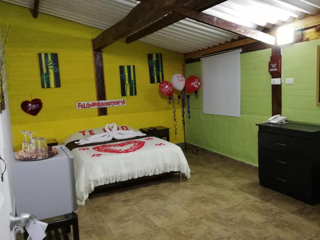 - une chambre avec un lit aux murs rouges et verts dans l'établissement Hotel Campestre El Refugio de Balsora, à Filandia