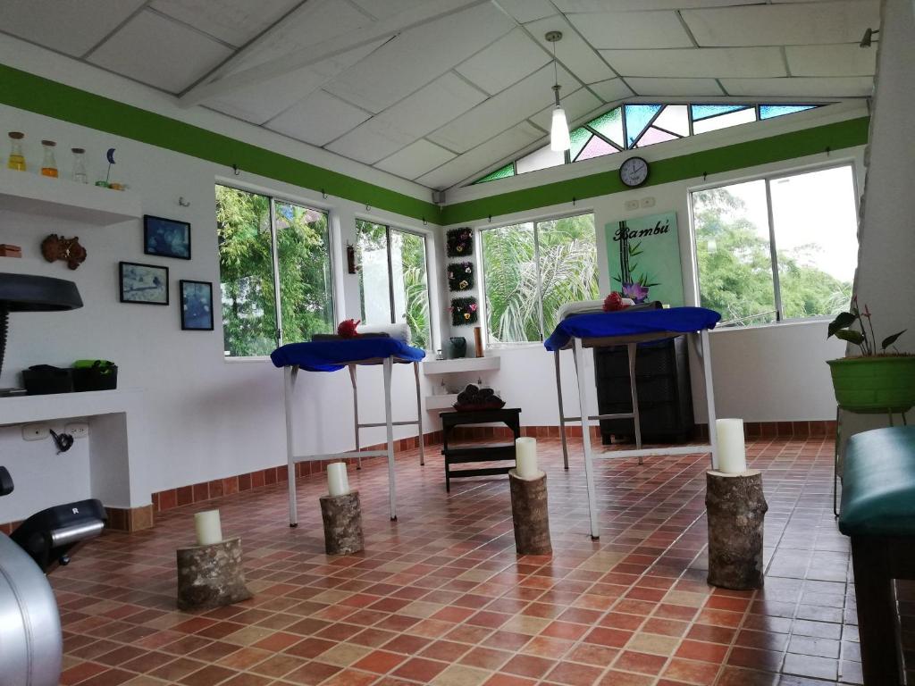 a room with two blue tables and some windows at Hotel Campestre El Refugio de Balsora in Filandia