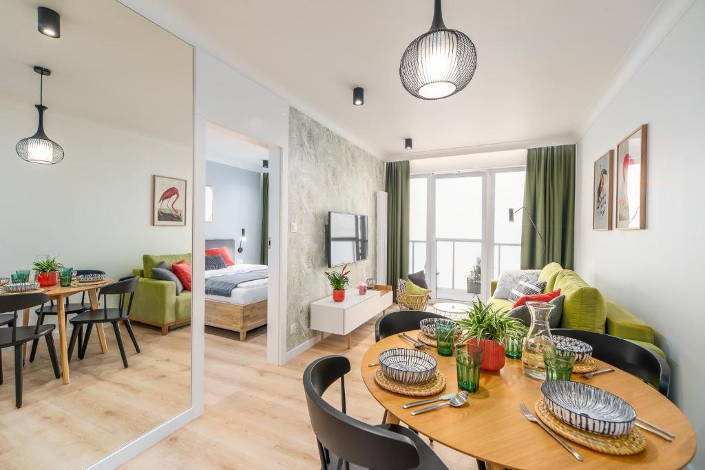 salon i jadalnia ze stołem i krzesłami w obiekcie BellMi Apartamenty - Parking Gratis, Plaża 5min, Komfort i Relaks w Kołobrzegu
