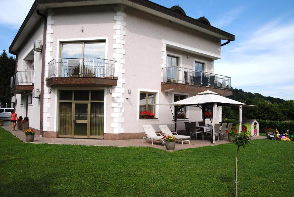 a white house with a patio and an umbrella at Studio apartmani Toplička bajka in Krapinske Toplice