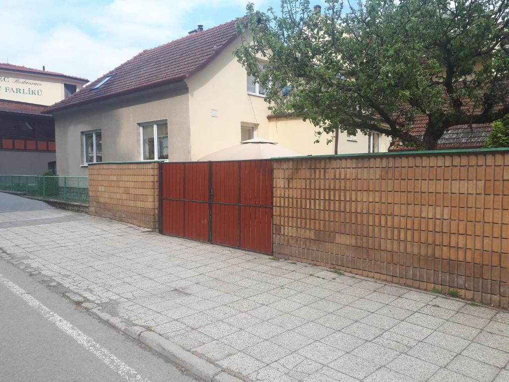 una cerca frente a una casa con una acera en Apartmán Křtiny, en Křtiny